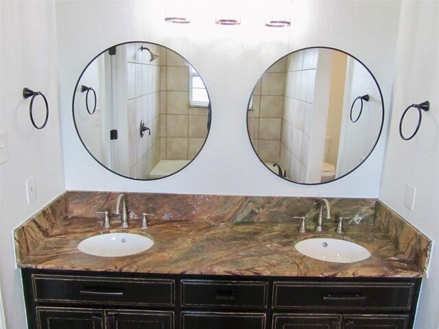 full bath featuring double vanity, toilet, and a sink