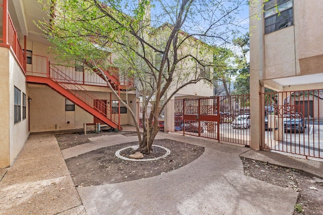 view of property's community featuring stairway, a patio, and fence