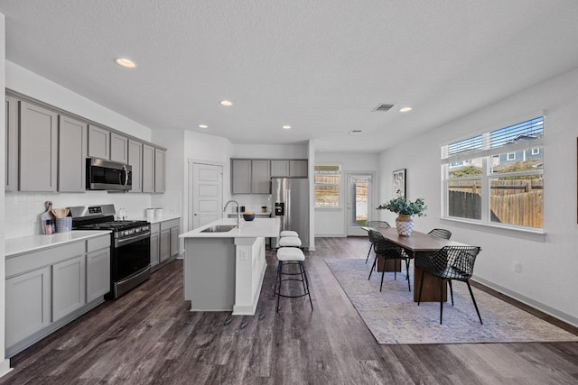 10410 Fulton Ave, Austin, TX 78754 - kitchen with appliances with stainless steel finishes, gray cabinets, a sink, a center island with sink, and recessed lighting