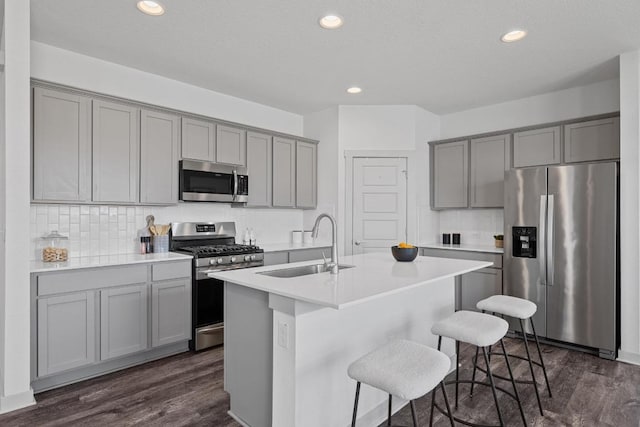 10410 Fulton Ave, Austin, TX 78754 - kitchen featuring appliances with stainless steel finishes, gray cabinets, a sink, dark wood finished floors, and recessed lighting