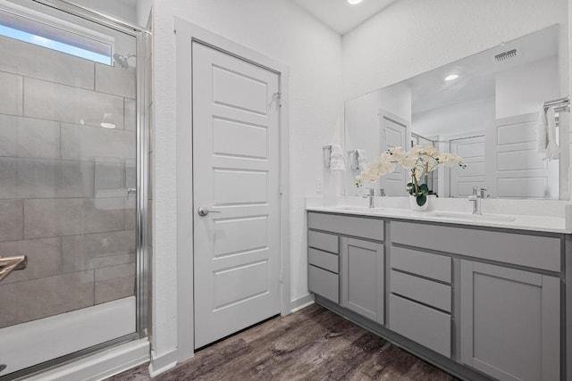 10410 Fulton Ave, Austin, TX 78754 - full bath with a shower stall, double vanity, and wood finished floors