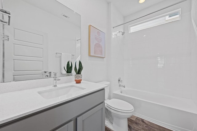 10410 Fulton Ave, Austin, TX 78754 - full bathroom with toilet, vanity, washtub / shower combination, and wood finished floors
