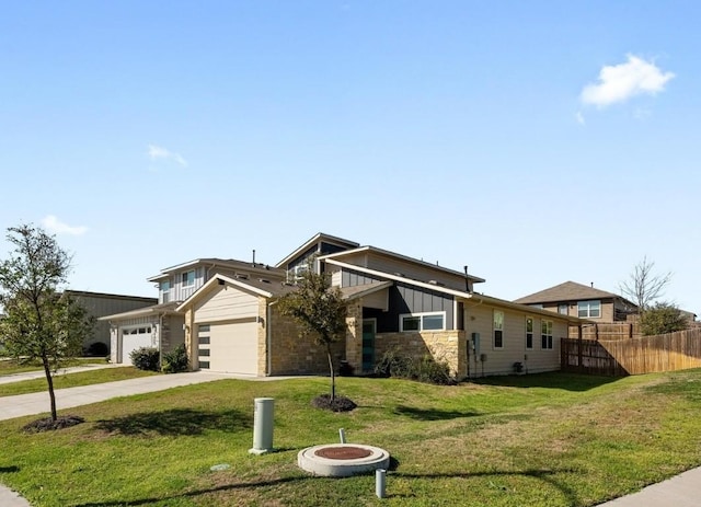 view of front of house with an attached garage, fence, concrete driveway, a front lawn, and board and batten siding