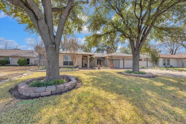 ranch-style home with a garage, brick siding, driveway, and a front yard