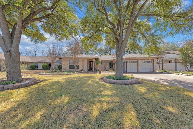 ranch-style house featuring an attached garage, driveway, and a front yard