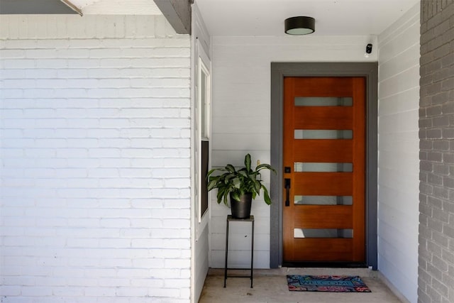 doorway to property featuring brick siding