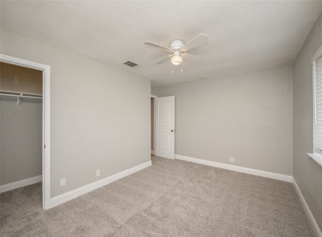 unfurnished bedroom featuring carpet floors, a closet, visible vents, a spacious closet, and baseboards