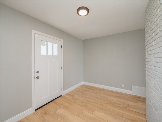 entryway with light wood-style floors, baseboards, and visible vents