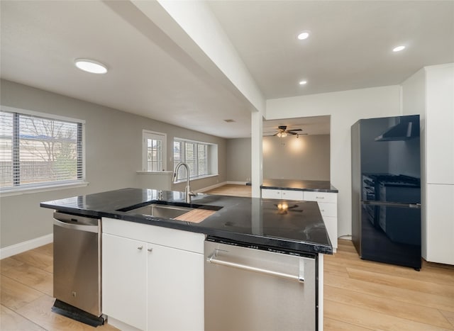 kitchen featuring stainless steel dishwasher, a sink, and light wood-style flooring