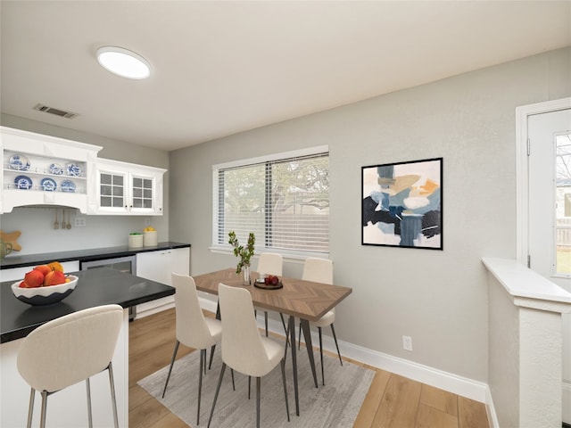 dining space featuring baseboards, visible vents, and light wood-style floors