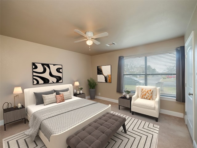 bedroom featuring baseboards, a ceiling fan, visible vents, and light colored carpet