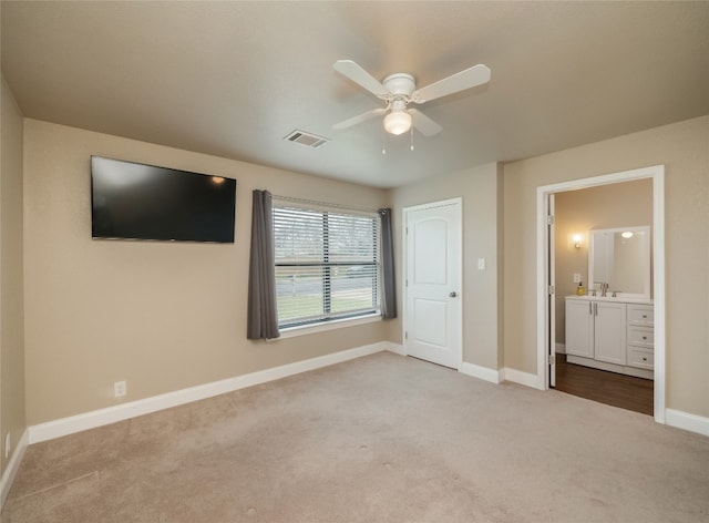 unfurnished bedroom with carpet, visible vents, a ceiling fan, ensuite bath, and baseboards