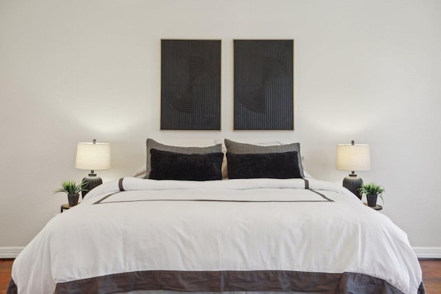 bedroom with wood finished floors and baseboards