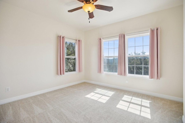 unfurnished room with baseboards, a ceiling fan, and light colored carpet