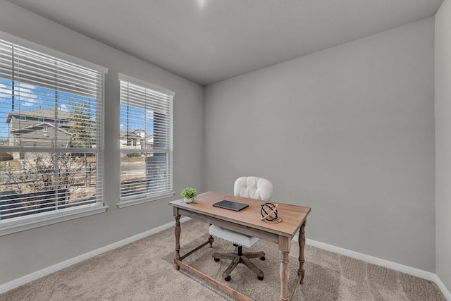 office space featuring baseboards and light colored carpet