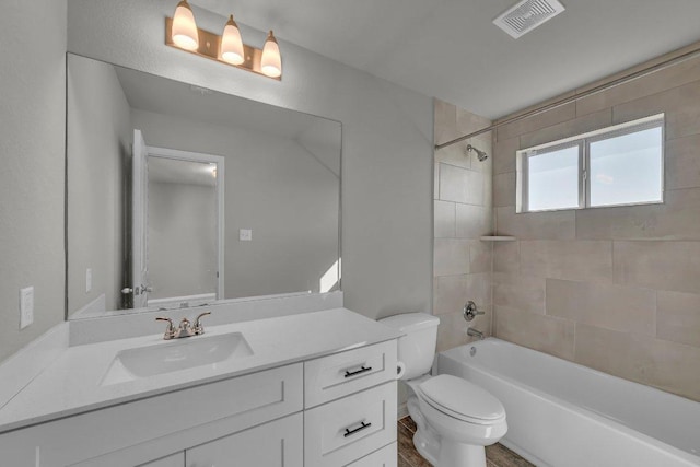 bathroom with visible vents, shower / bathing tub combination, vanity, and toilet