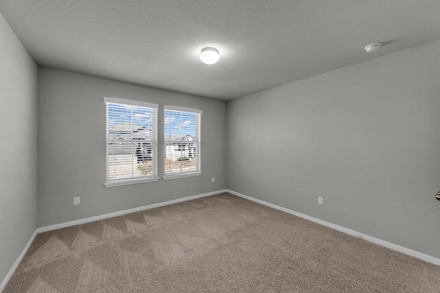 unfurnished room featuring carpet floors, baseboards, and a textured ceiling