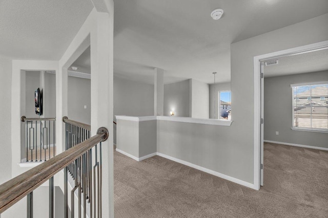 corridor featuring carpet, baseboards, visible vents, and an upstairs landing