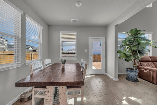 dining area featuring visible vents, baseboards, and wood finished floors