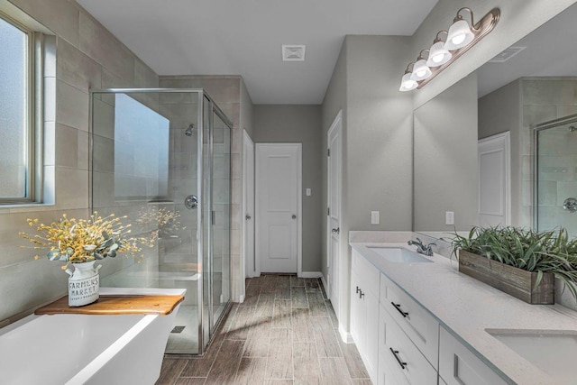 full bathroom with a stall shower, wood tiled floor, and a sink