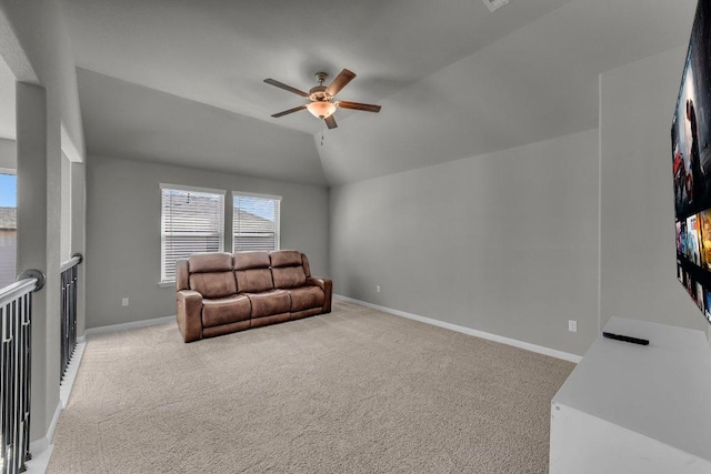 living area with a ceiling fan, lofted ceiling, light carpet, and baseboards