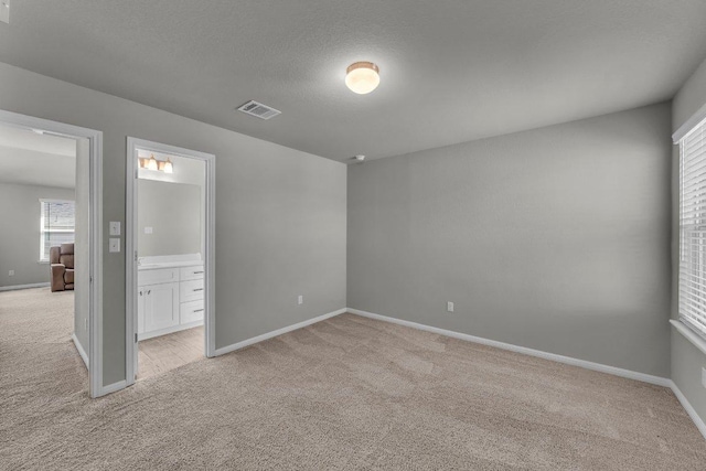 unfurnished bedroom with light carpet, baseboards, and visible vents