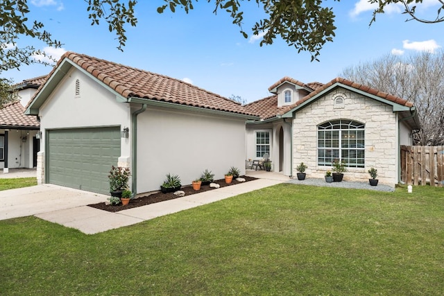 mediterranean / spanish house featuring a tile roof, fence, a garage, stone siding, and a front lawn