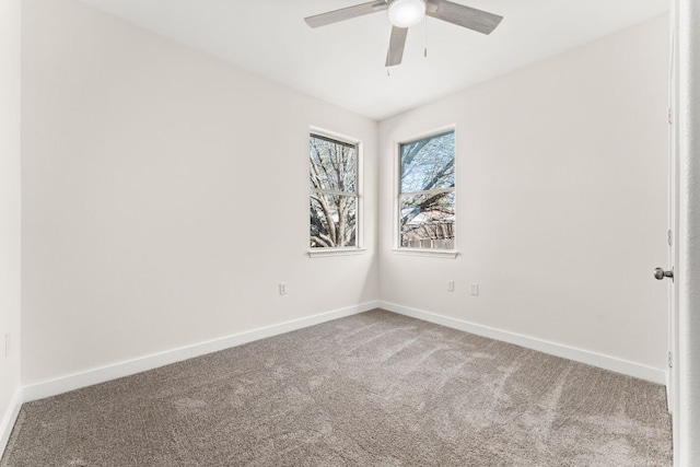 carpeted spare room featuring ceiling fan and baseboards