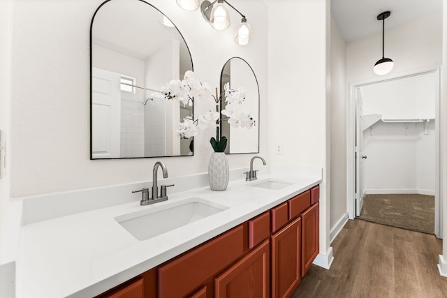 5604 Toscana Ave, Austin, TX 78724 - full bath featuring wood finished floors, double vanity, tiled shower, and a walk in closet