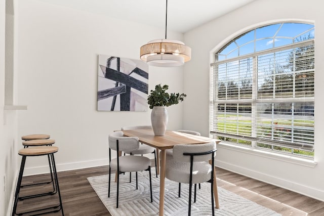 dining area with plenty of natural light, baseboards, and dark wood-type flooring