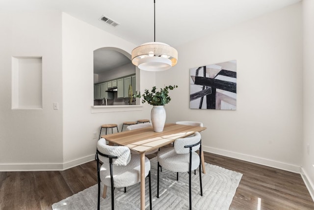 dining area featuring dark wood-style floors, visible vents, and baseboards