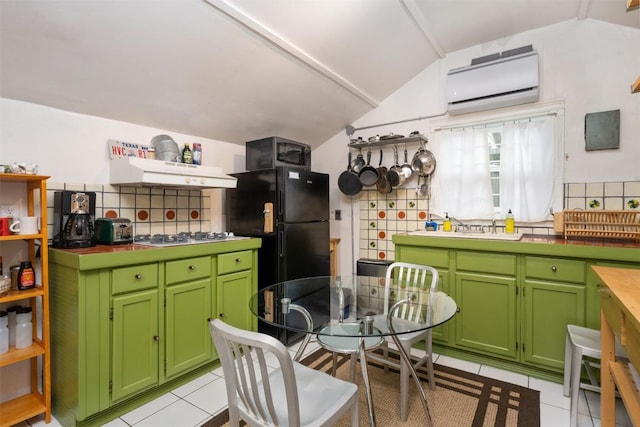 2300 Willow St, Austin, TX 78702 - kitchen featuring lofted ceiling, extractor fan, light tile patterned floors, a wall unit AC, and freestanding refrigerator