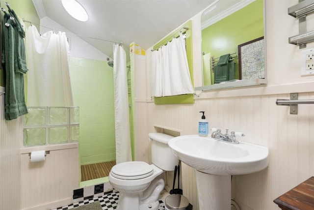 bathroom with tile patterned floors, toilet, a sink, a tile shower, and vaulted ceiling