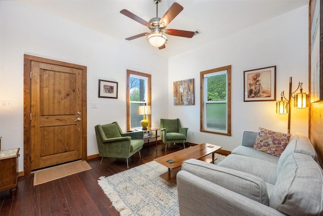 living area featuring baseboards, dark wood-style flooring, and ceiling fan