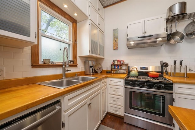 kitchen featuring a sink, stainless steel appliances, under cabinet range hood, white cabinetry, and butcher block counters