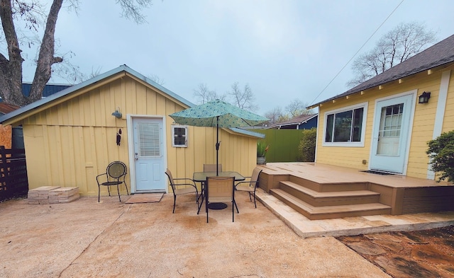 exterior space featuring a patio, outdoor dining area, a deck, and fence