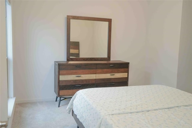 bedroom with light carpet and baseboards