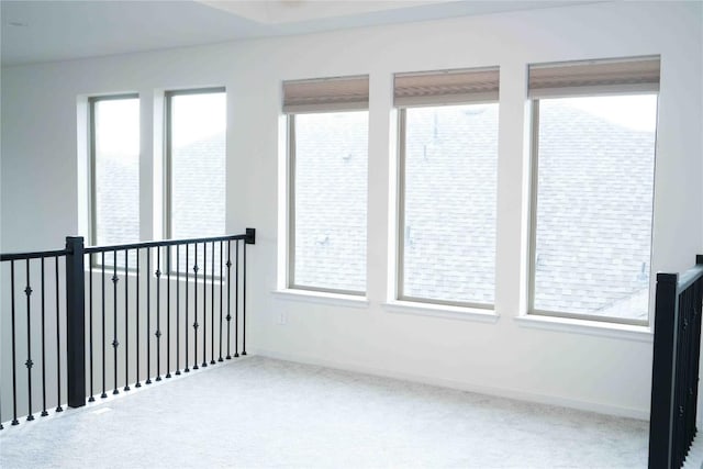 carpeted spare room with baseboards and a healthy amount of sunlight