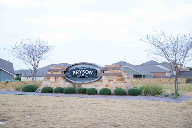 community / neighborhood sign with a residential view and a lawn