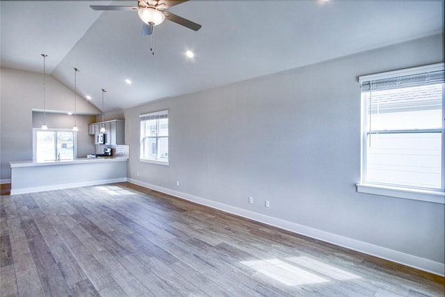 205 Pinnacle Ln, Kyle, TX 78640 - unfurnished living room with ceiling fan, dark wood finished floors, lofted ceiling, and baseboards