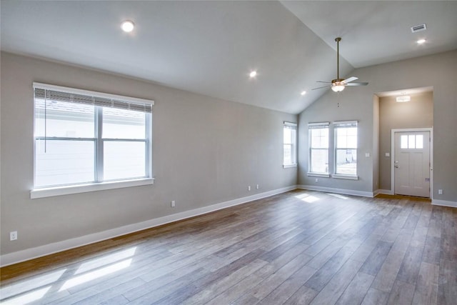 unfurnished living room featuring baseboards, visible vents, a ceiling fan, wood finished floors, and vaulted ceiling