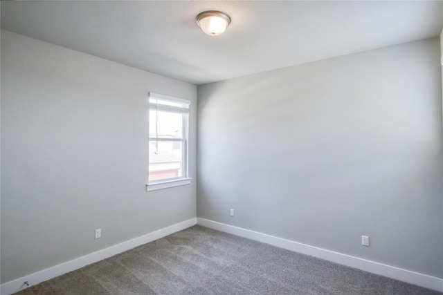 unfurnished room with carpet floors and baseboards