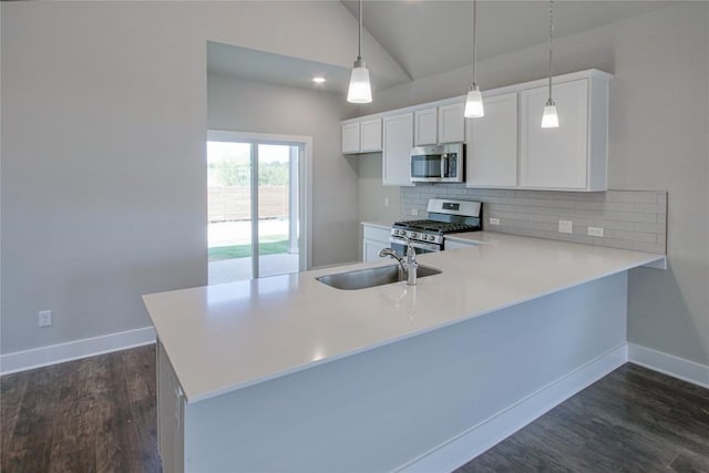 kitchen with tasteful backsplash, lofted ceiling, appliances with stainless steel finishes, light countertops, and a sink