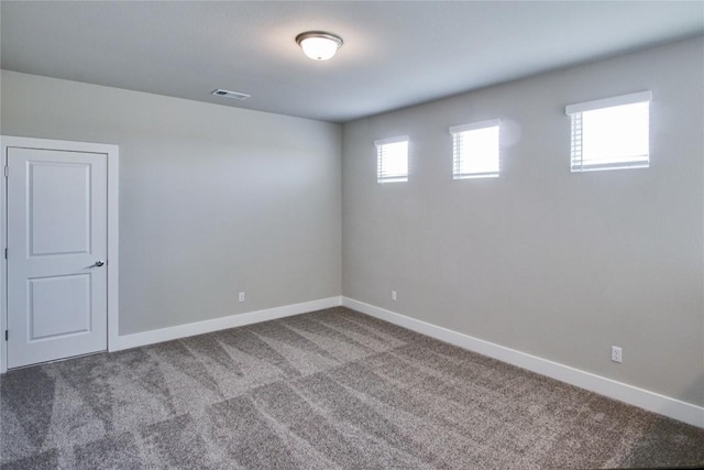 empty room featuring baseboards, visible vents, and carpet flooring