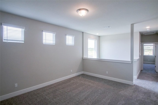 carpeted spare room featuring baseboards and visible vents