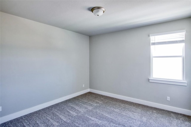 carpeted empty room with baseboards