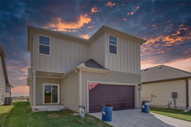 view of front of home featuring board and batten siding, central AC, a garage, driveway, and a front lawn