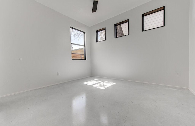 unfurnished room featuring concrete floors, baseboards, and a ceiling fan