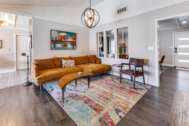 living room featuring vaulted ceiling, a notable chandelier, wood finished floors, and visible vents