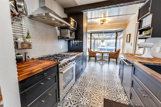 kitchen with backsplash, wooden counters, stainless steel appliances, wall chimney exhaust hood, and open shelves